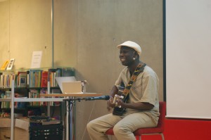 A man sitting and playing on a guitar.
