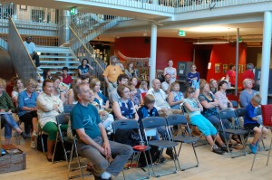 Many people sitting and watching a presentation.