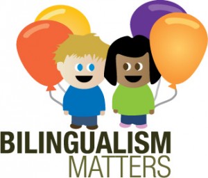 Illustration of two children smiling at each other with two balloons behind each of them. "Bilingualism Matters"