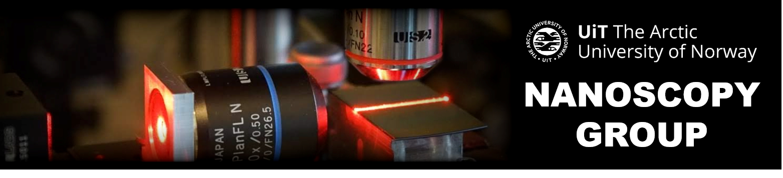 A laser line coming from an objective lens is guided horizontally across a photonic chip while a second, perpendicular objective lens captures an image from the top of the chip.