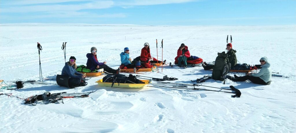 personer sitter på snøen, tar seg pause, vinterlandskap og snø